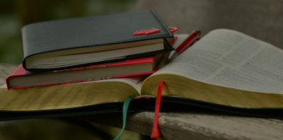 Two books stacked on top of an open book