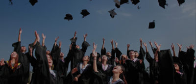 A group of graduating students throwing their caps in the air