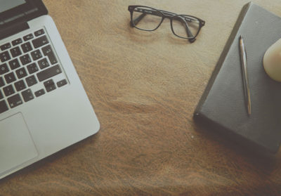 laptop, notepad, pen, and glasses