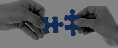 Two hands placing puzzle pieces together