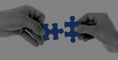Two hands placing puzzle pieces together