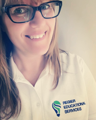 Picture of Patricia Regier, wearing glasses, smiling, Regier Educational Services logo on shirt