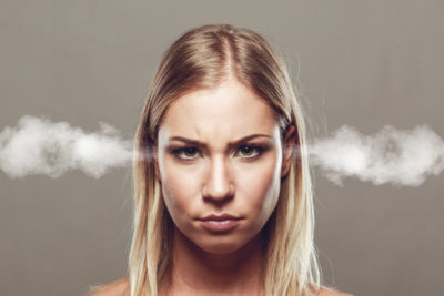 A woman with an unhappy facial expression and steam coming from her ears