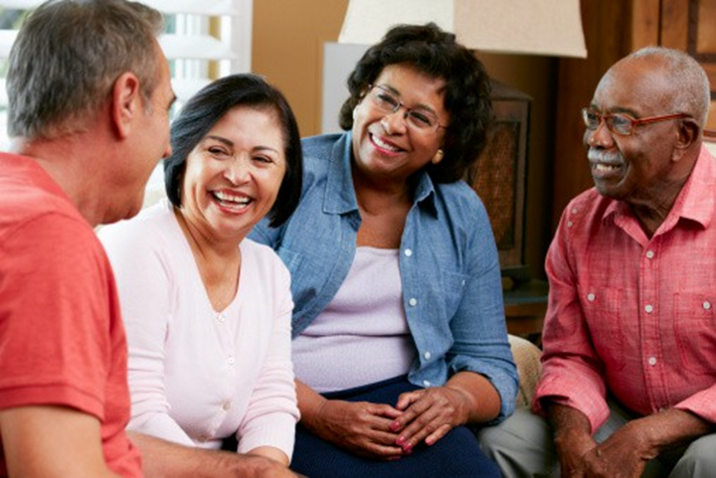 A group of people sitting together, smiling and laughing