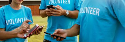 a group of volunteers all looking at their cellphones