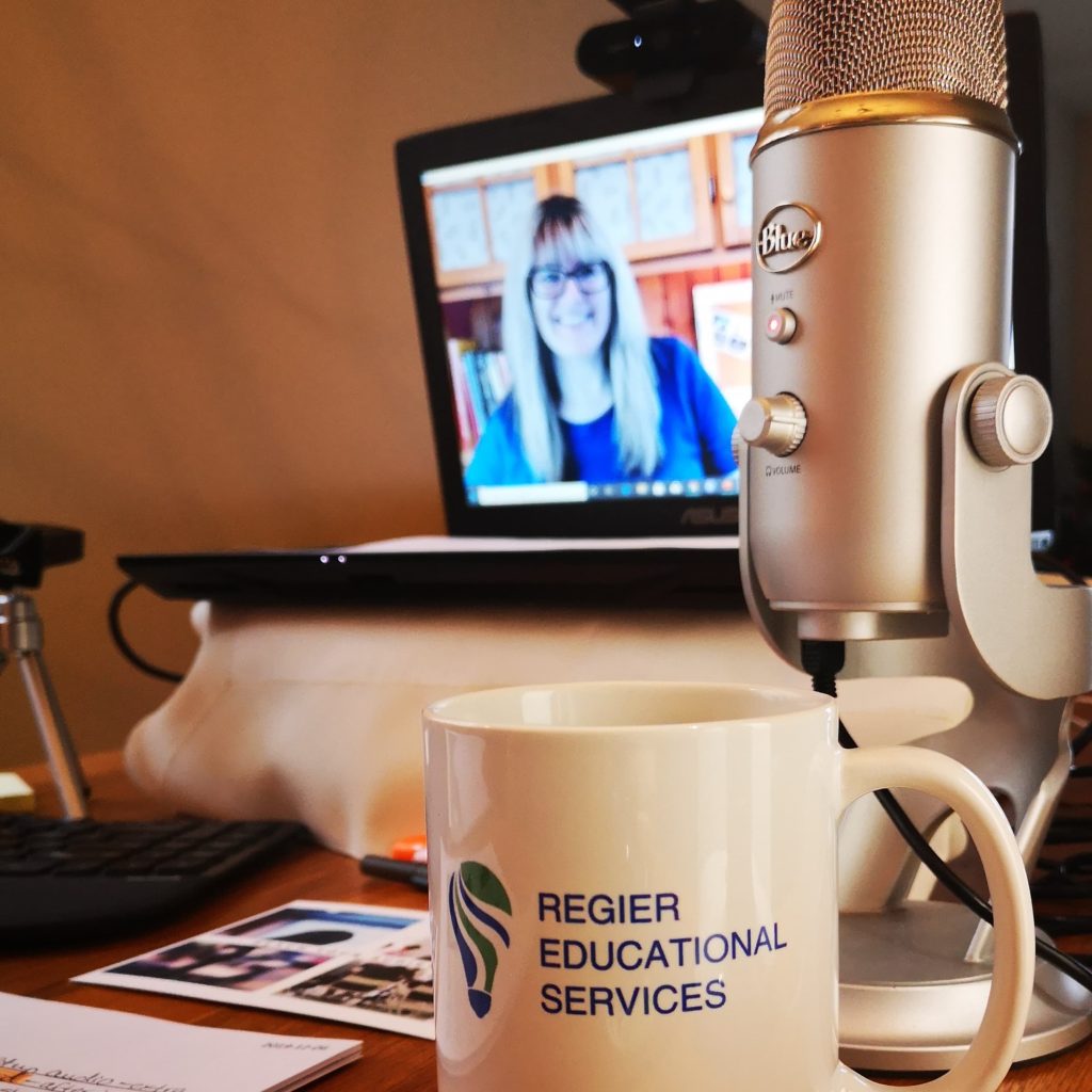 patricia shown on computer screen, showing her desk, mic, mug and set up for an online workshop
