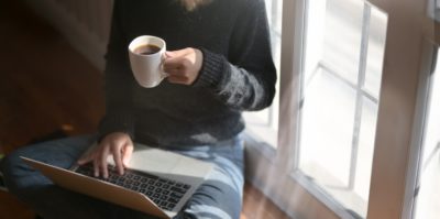 having a coffee and joining a meeting on a laptop