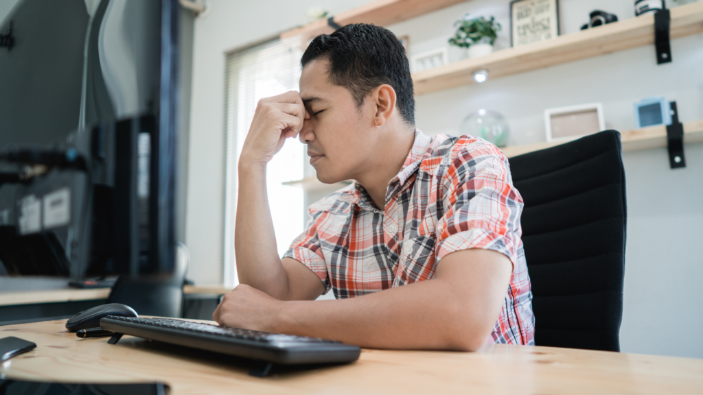 man disappointed when looking at computer screen