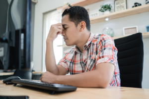 man disappointed when looking at computer screen