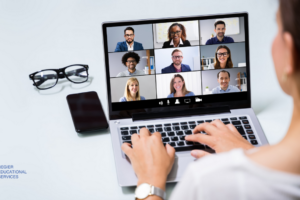 woman typing on laptop with 9 people on video conference who may have Zoom Fatigue