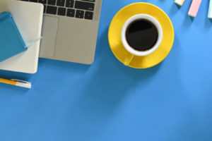blue desk top, laptop, yellow coffee cup
