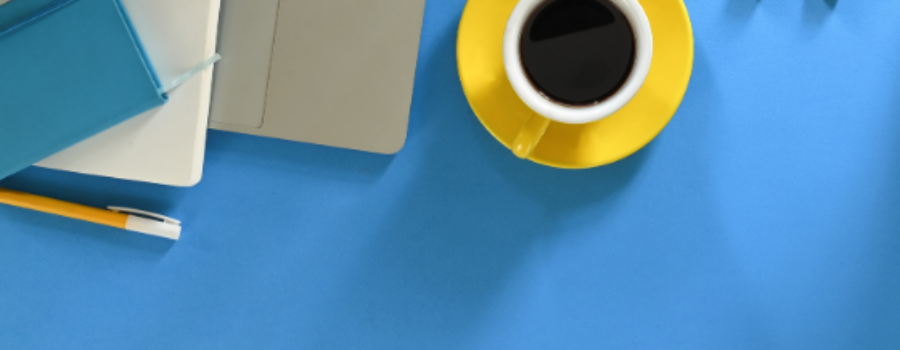 blue desk top, laptop, yellow coffee cup