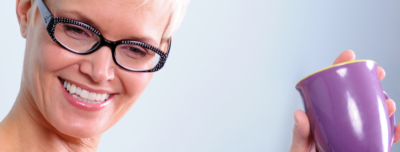 woman smiling with a cup of tea