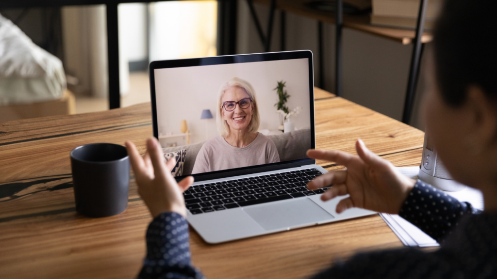 woman smiling on computer, as a person watching laptop training session online