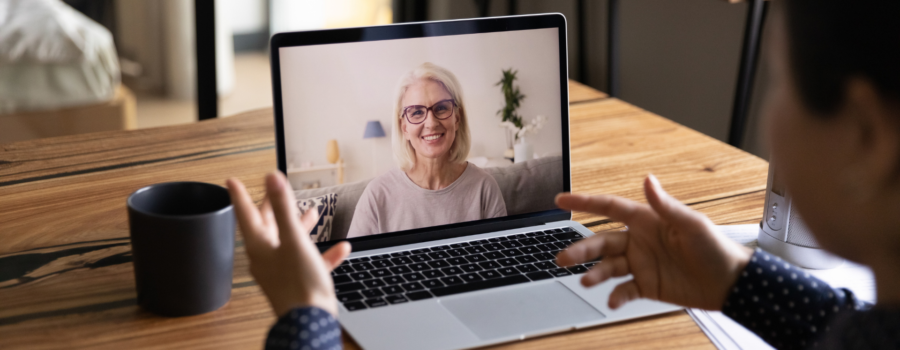 woman smiling on computer, as a person watching laptop training session online