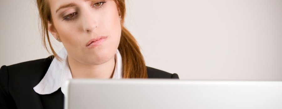 woman looking tired and staring at her computer screen