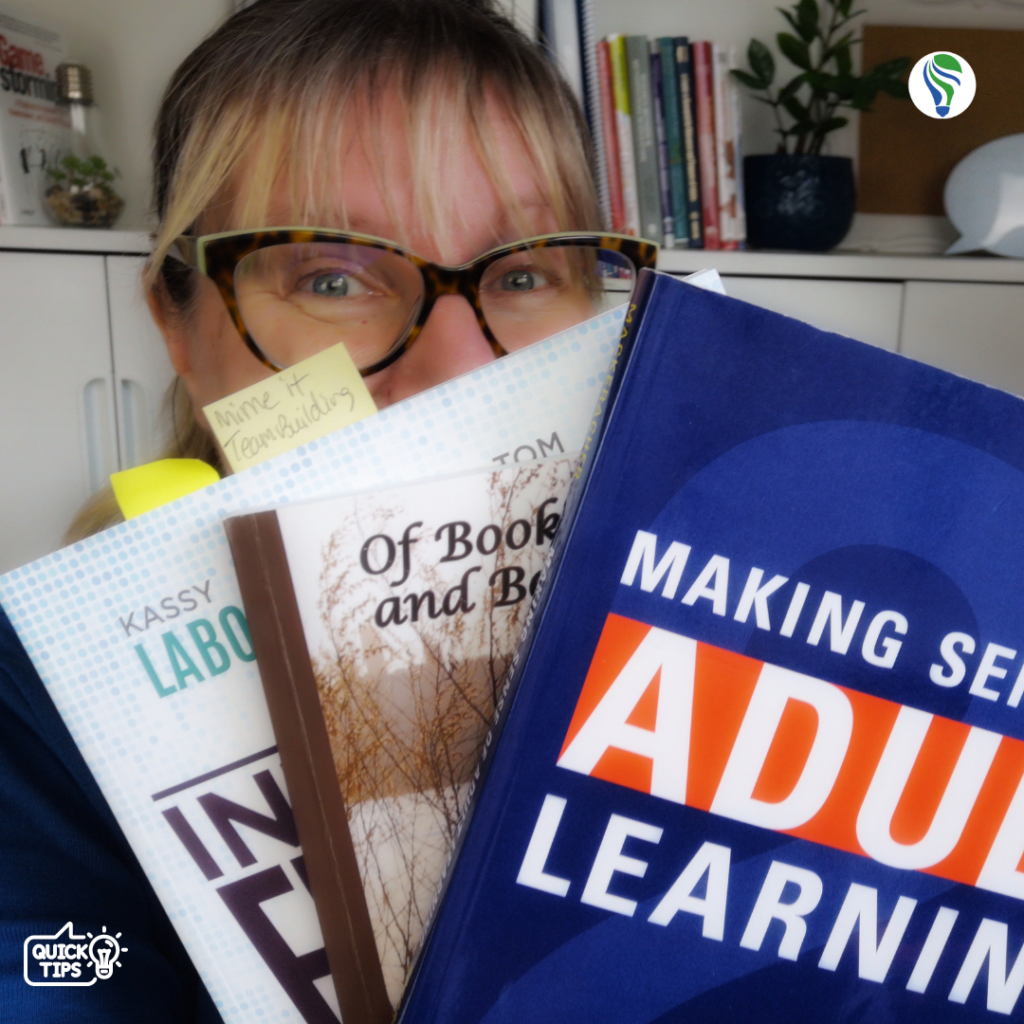 picture of woman holding several books on her summer reading list