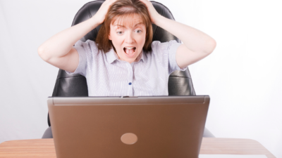 computer crashed woman pulling hair and looking at laptop