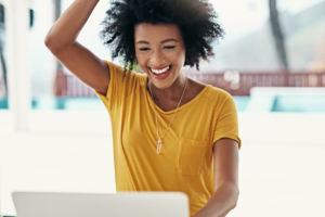 image of woman with laptop happy about new Zoom Breakout Rooms Feature