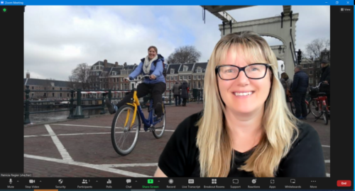 patricia in front of a zoom virtual background with a picture from a trip