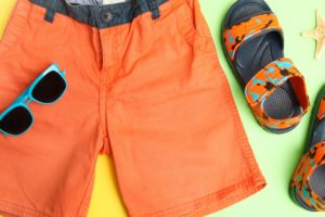 image of orange shorts and sandles with blue sunglasses on a yellow and green background for hot pro tips