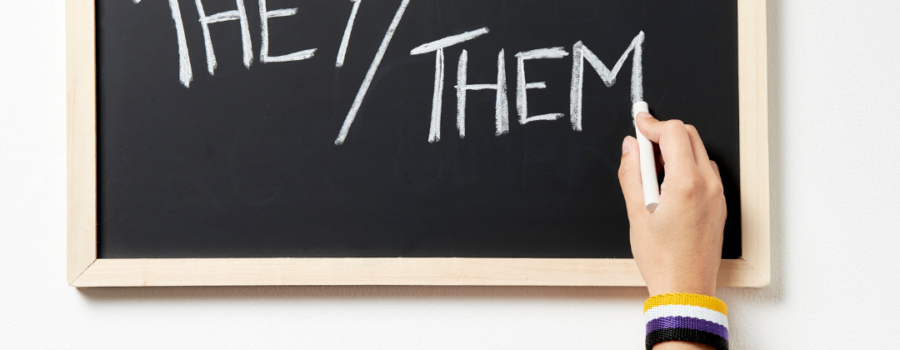 Zoom Pronouns chalk board and hand with chalk writing they/them