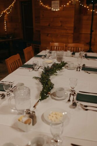a table set with garland, pinecones, napkins and cutlery. Credit to Roxanne Duke Photographer