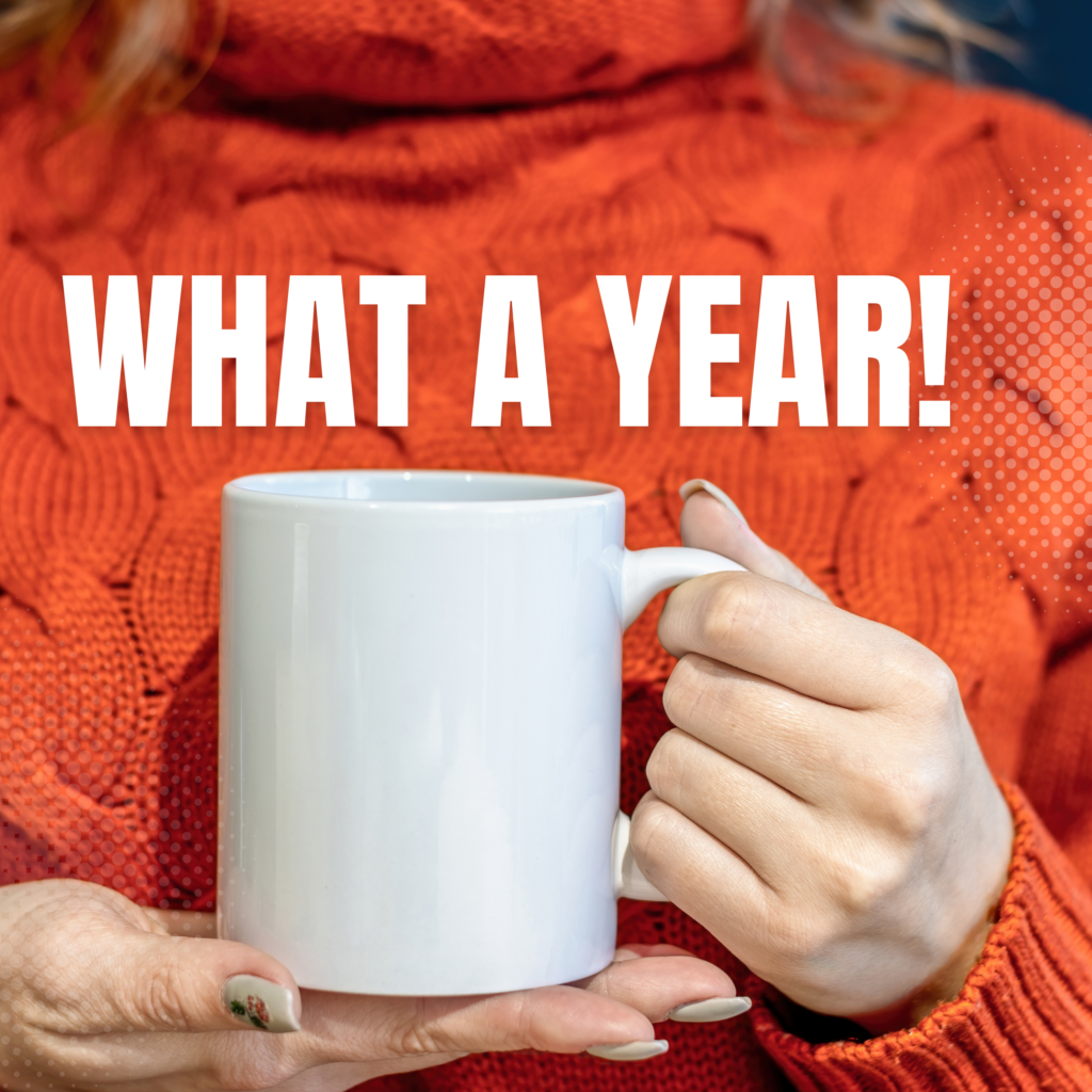 looking back blog image of a woman in an orange sweather holding a white mug, words what a year