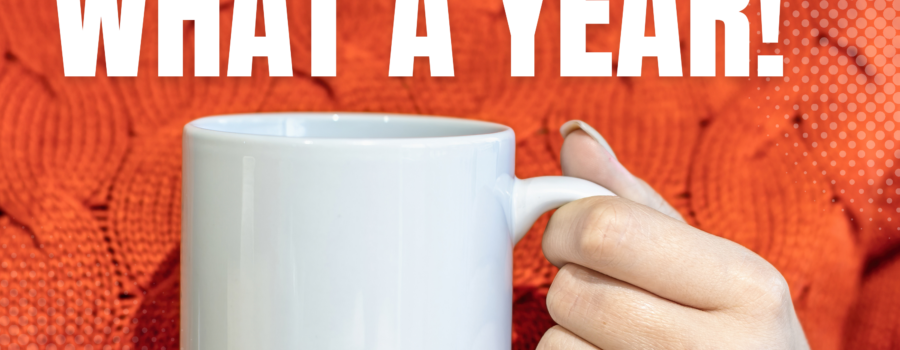looking back blog image of a woman in an orange sweather holding a white mug, words what a year