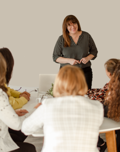 Patricia speaking to a group. She is a white woman with brown hair wearing a black and white striped top and black pants