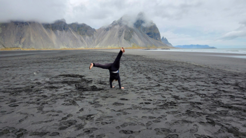 Patricia doing a kart wheel on a beach in Iceland